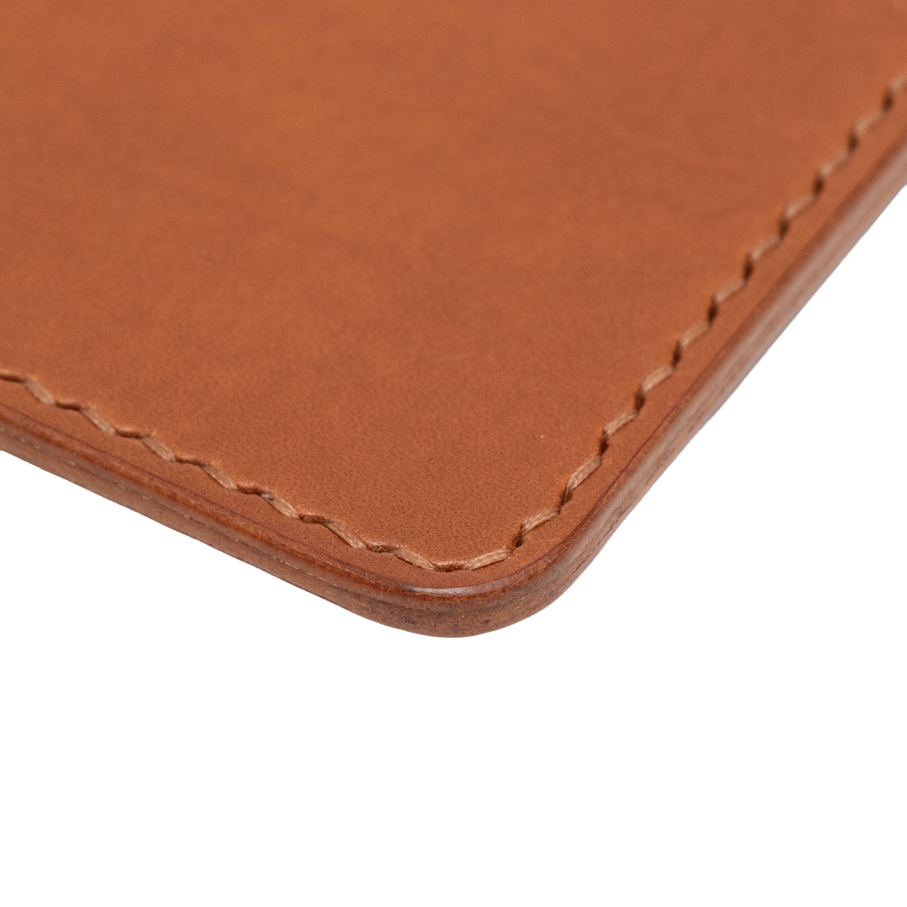 Close-up of a brown leather passport holder with visible stitching on a white background