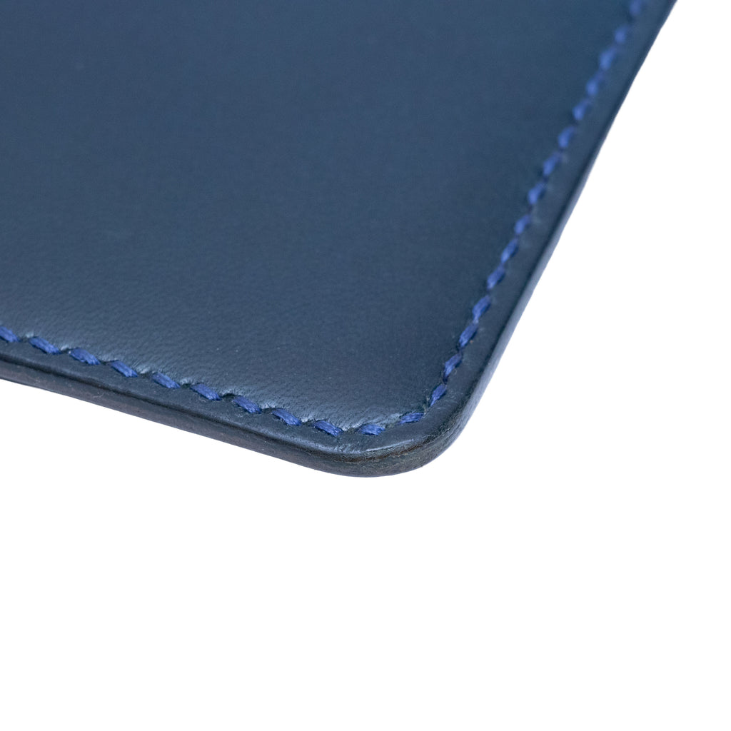 Close-up of a blue leather passport holder with visible stitching on a white background