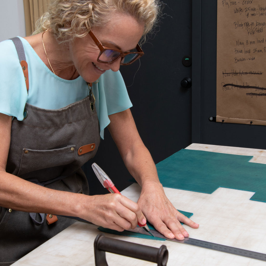 Woman in apron working on a tote project at a table