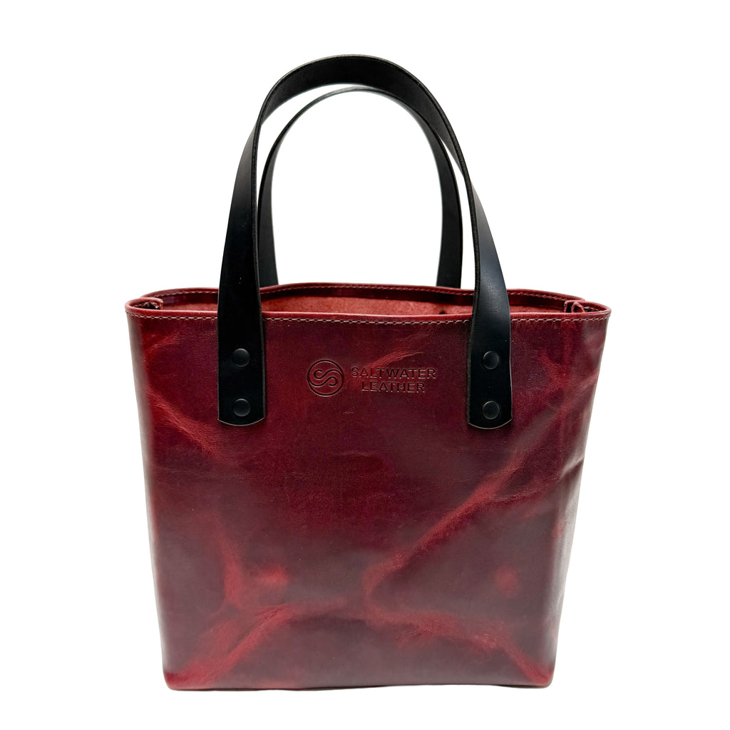 Red tote bag with black handles on a white background