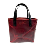 Red tote bag with black handles on a white background