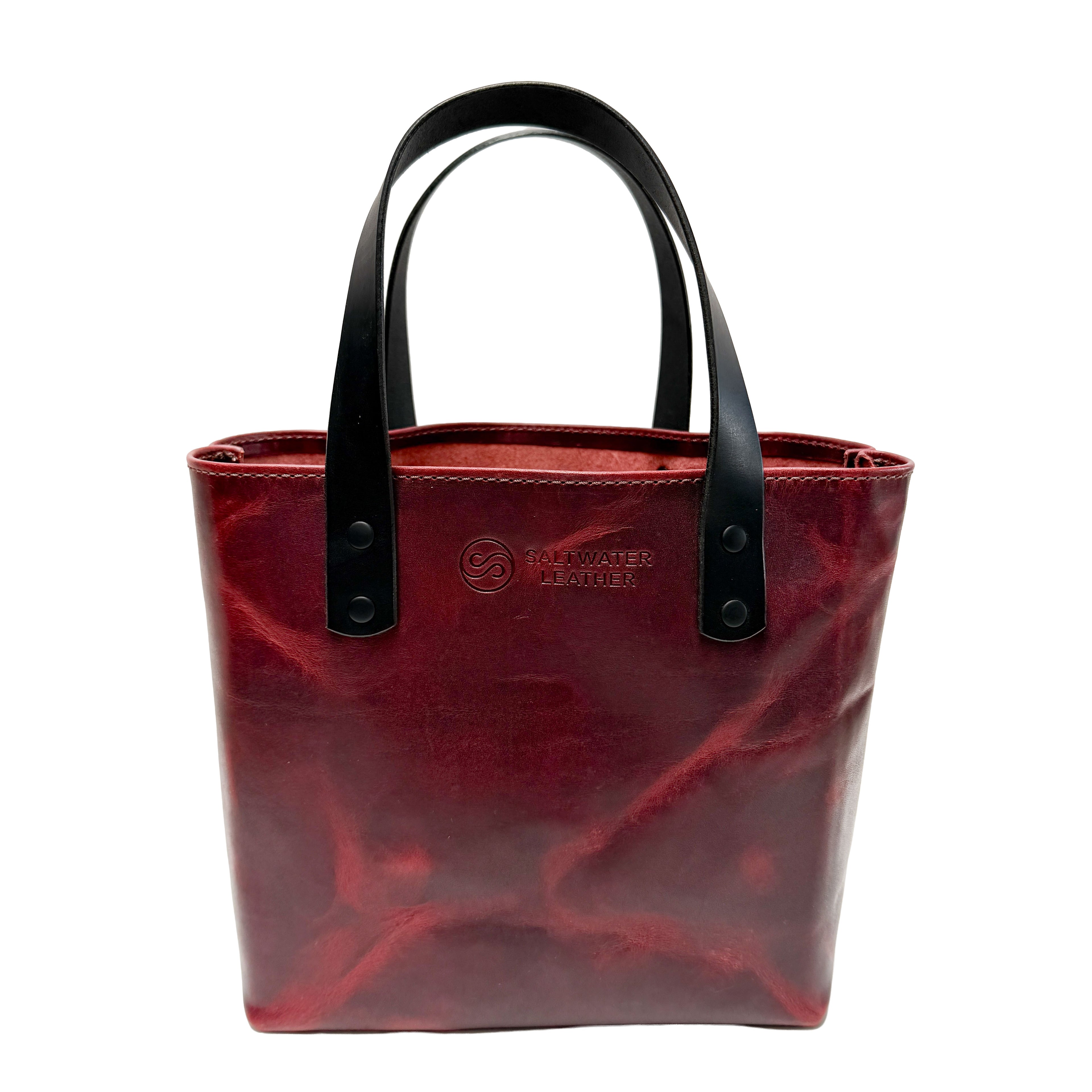 Red tote bag with black handles on a white background