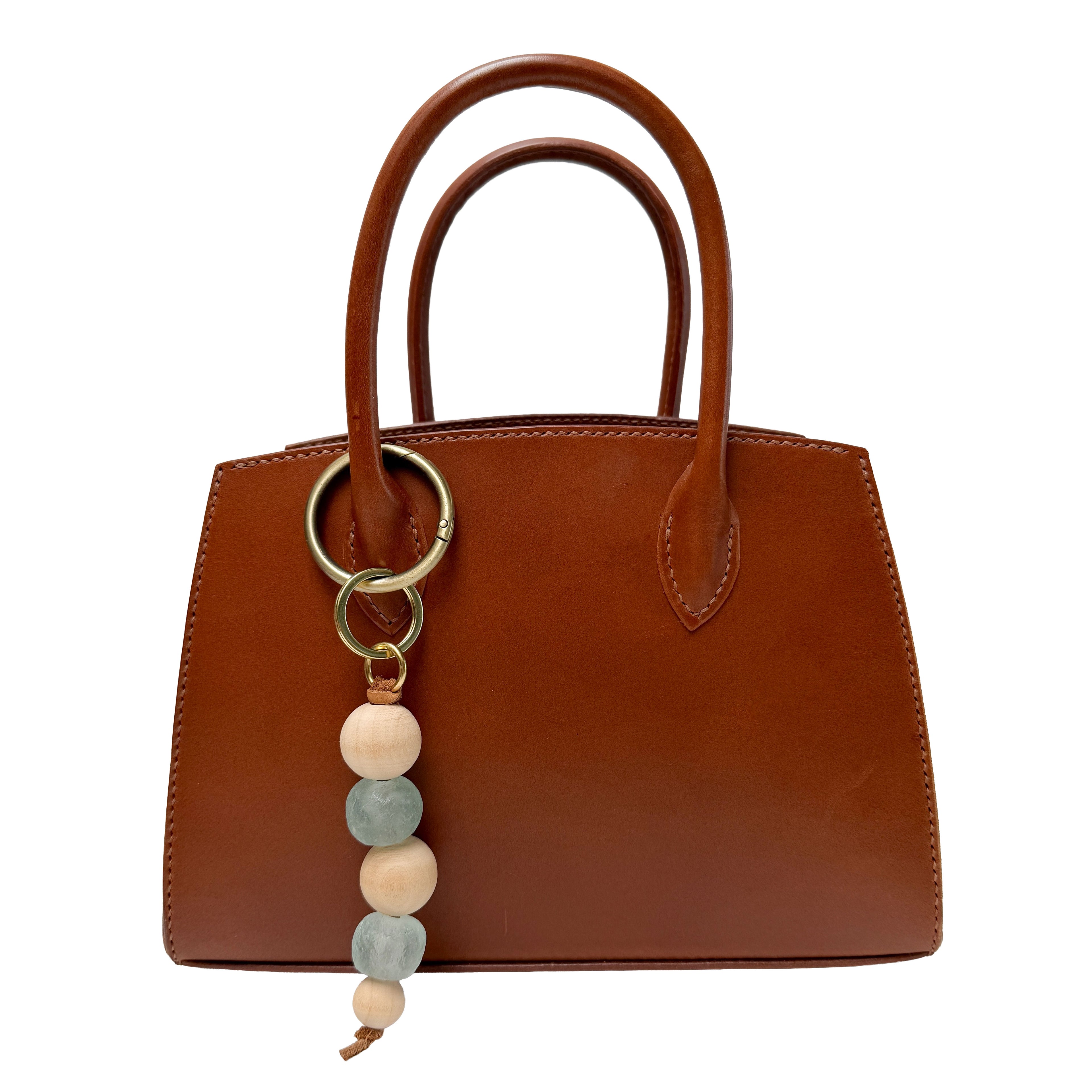 Brown handbag with a keychain featuring colorful beads on a white background