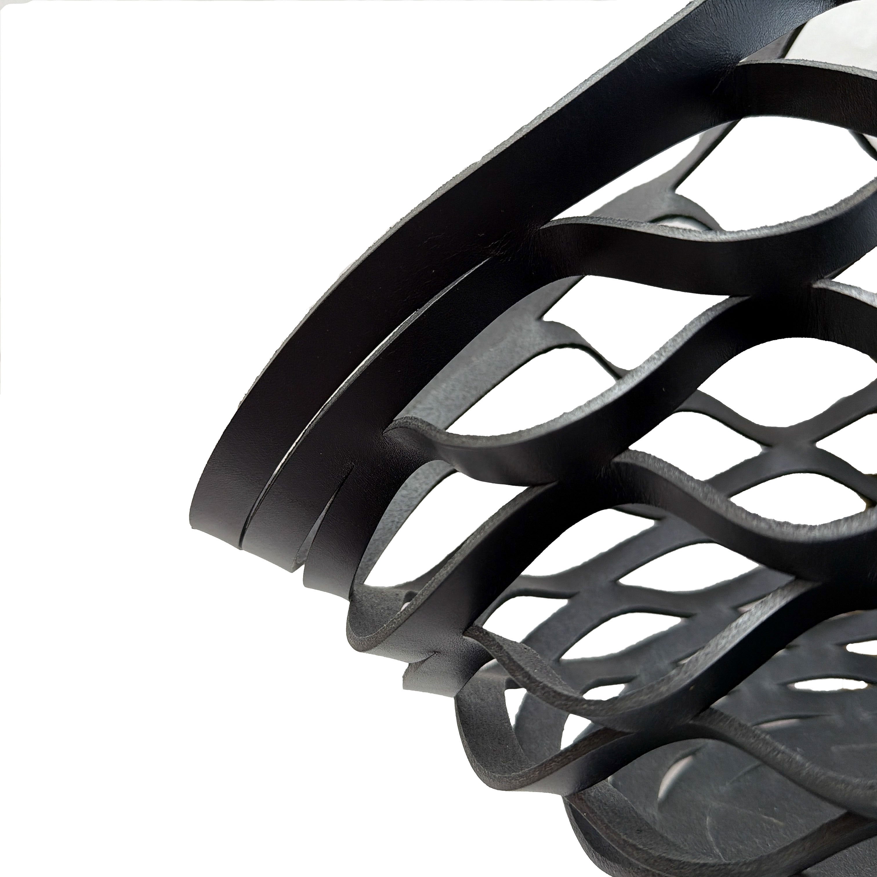 Close-up of a black leather woven bag on a white background