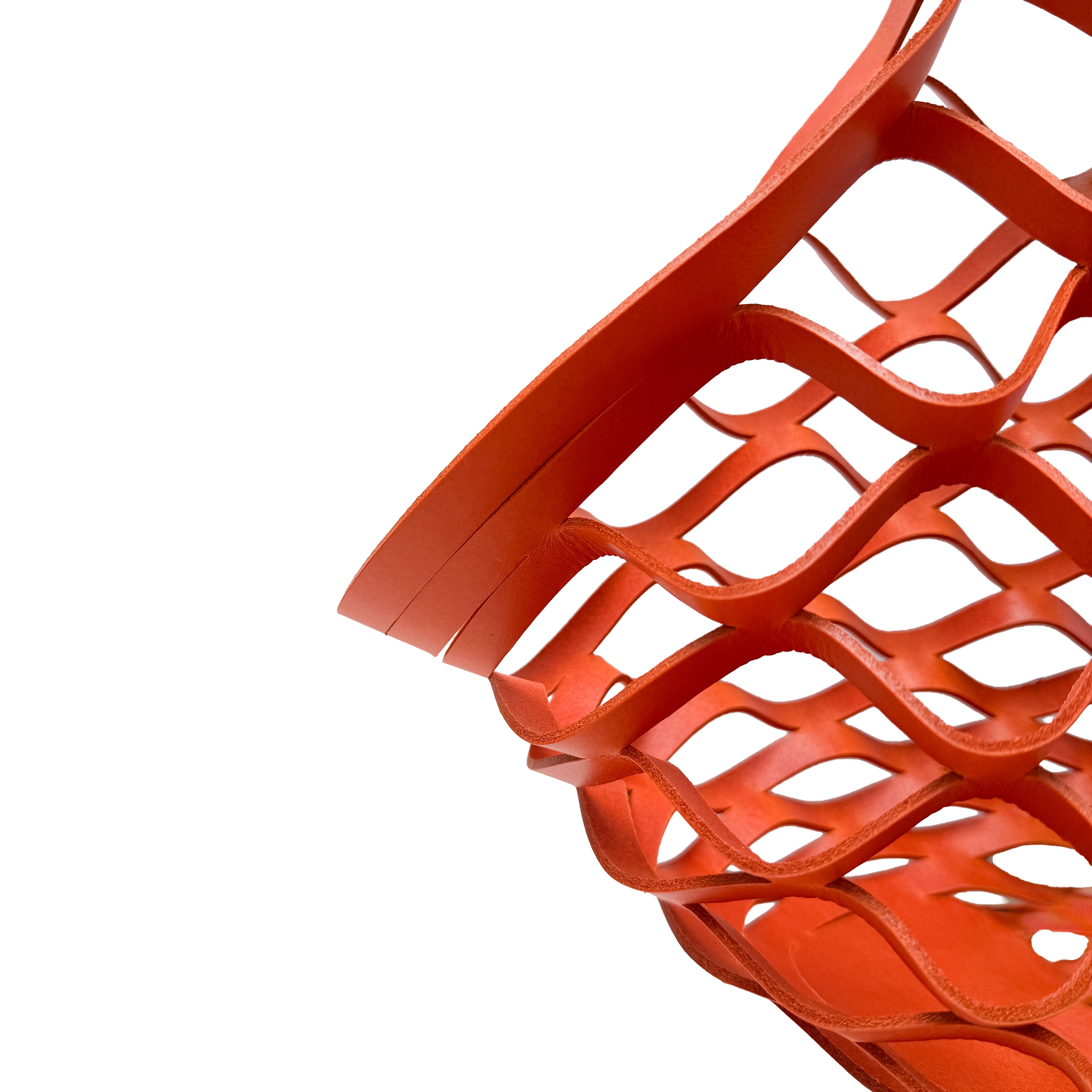 Close-up of a red leather woven basket on a white background