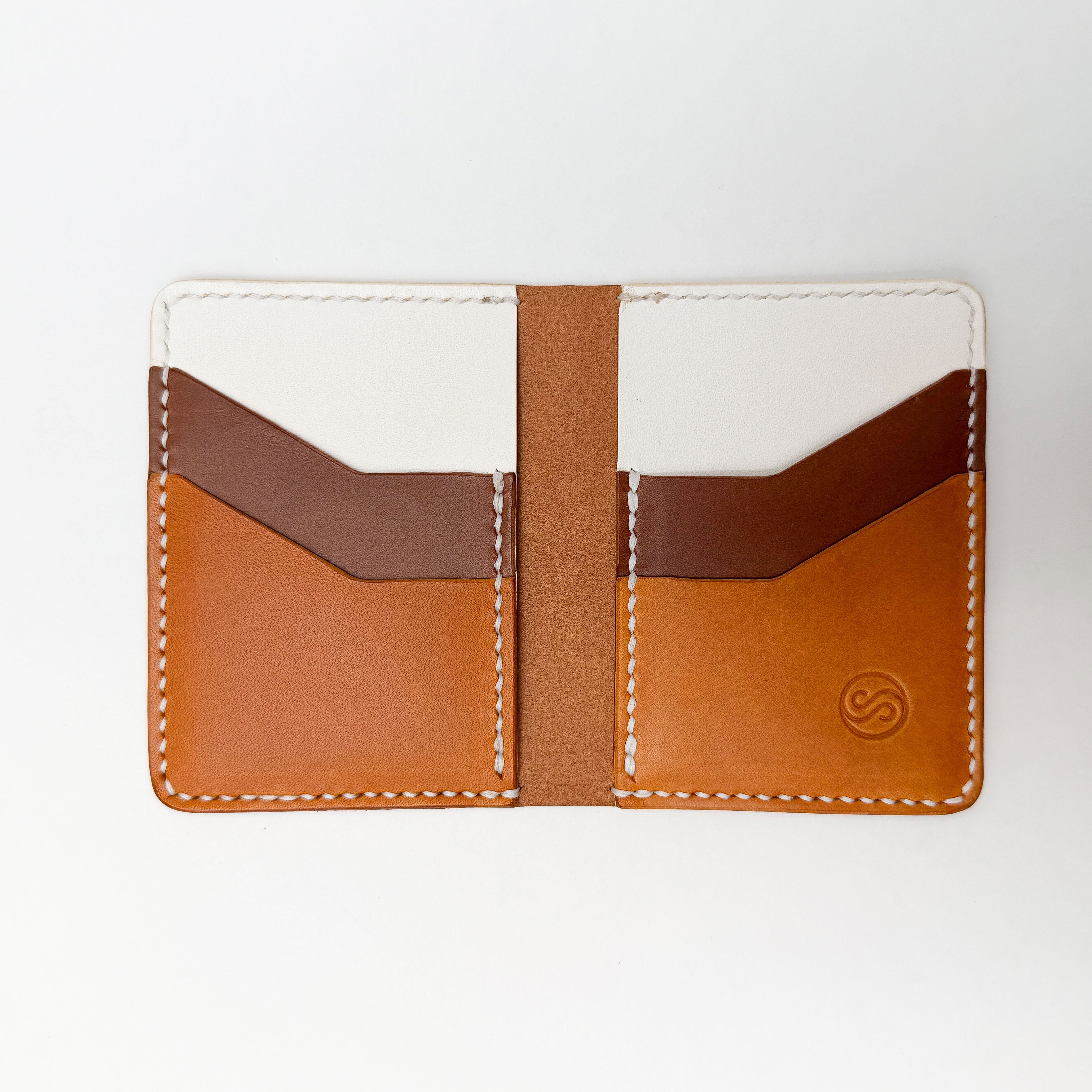 Three-tone leather cardholder with brown and white sections on a white background