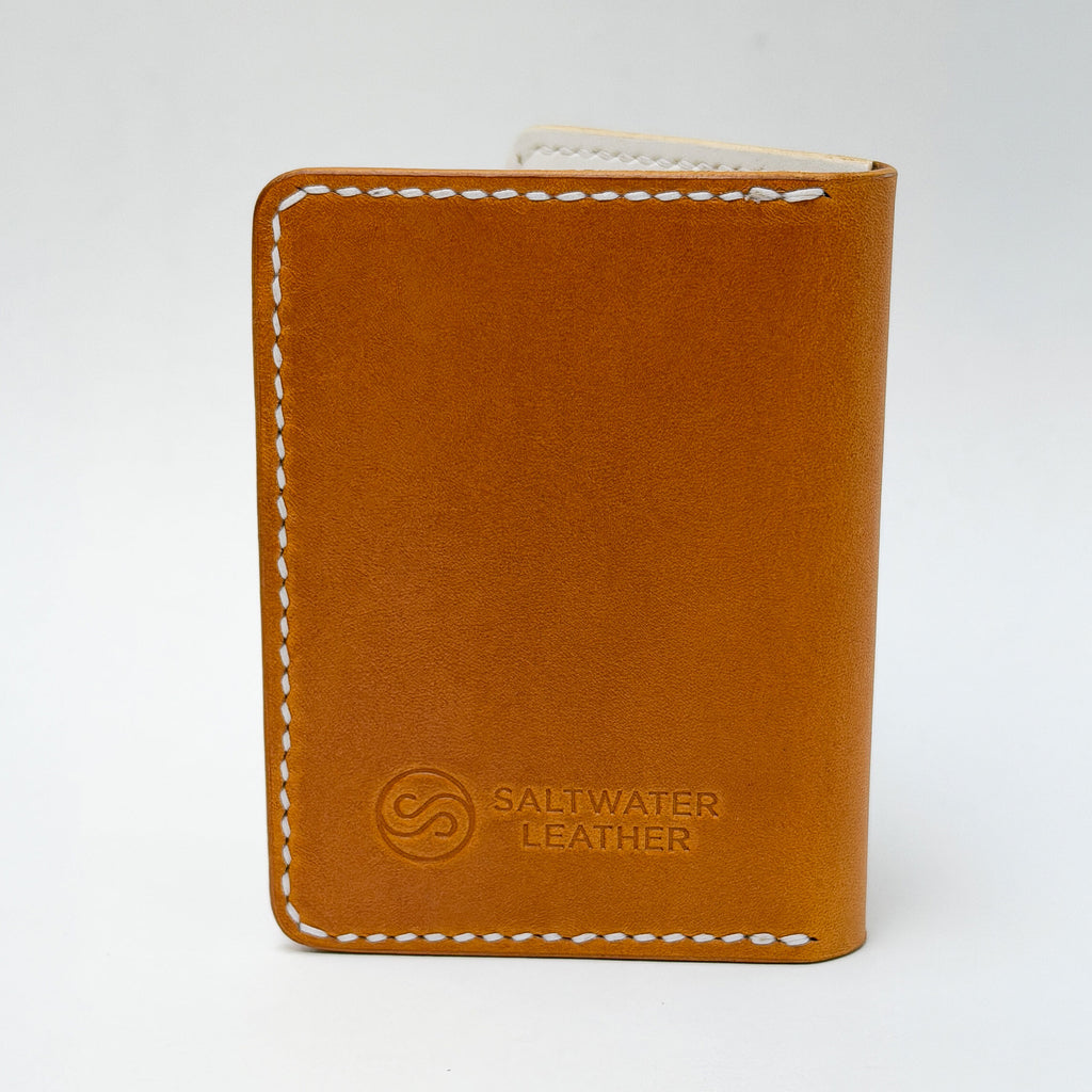 Yellow leather wallet with 'Saltwater Leather' branding on a white background