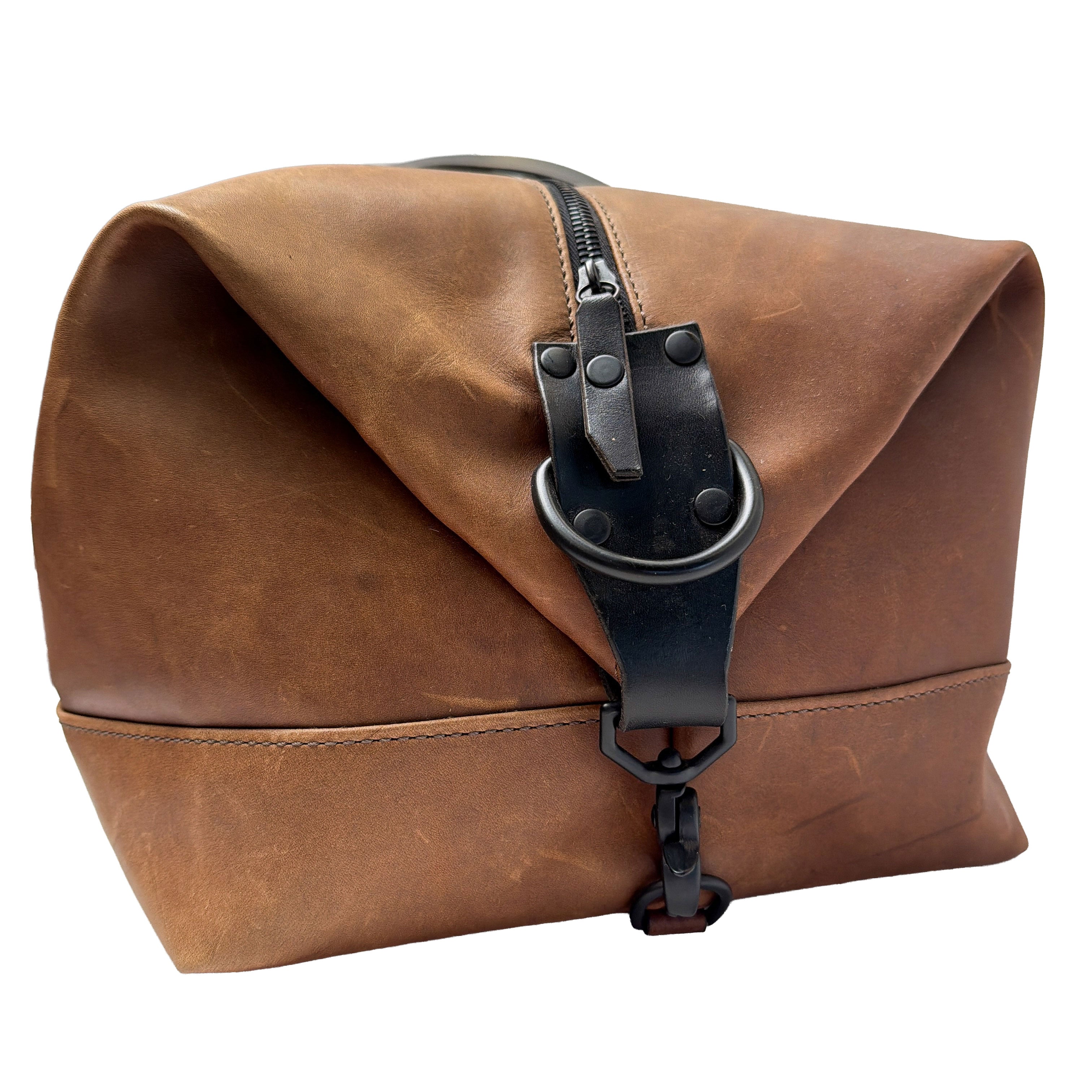Brown leather duffle with black strap and buckle on a white background