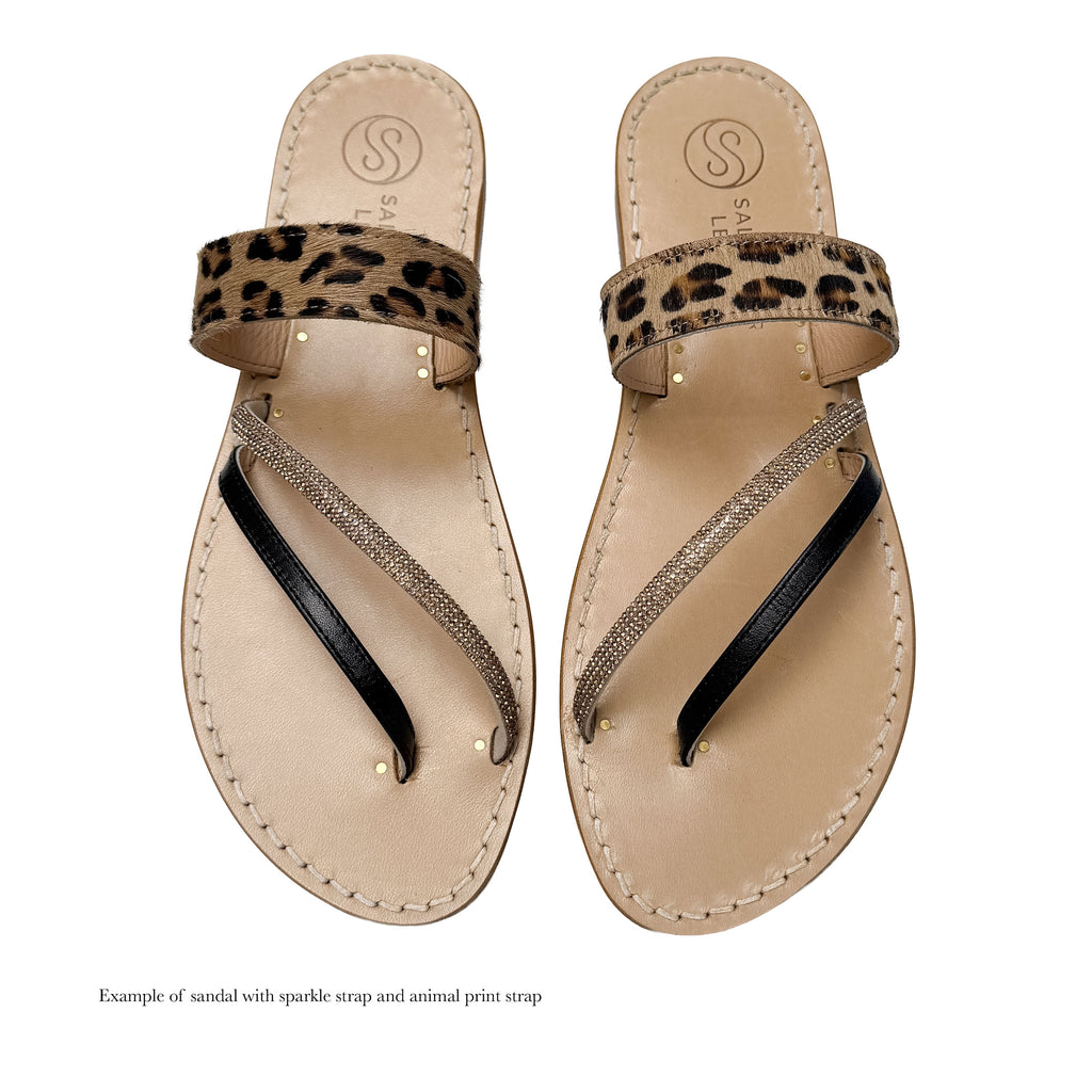 Pair of sandals with leopard print strap and sparkling details on a white background