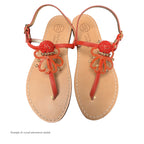Pair of sandals with red crystal embellishments on a white background