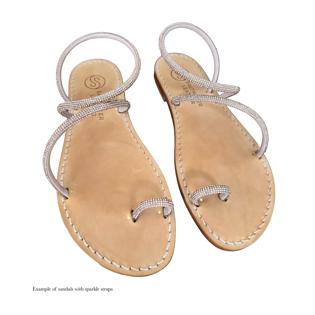 Pair of sandals with sparkly straps on a white background